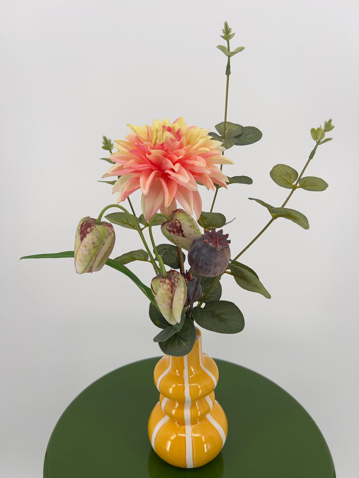 Geel vaasje met witte streep gevuld met diverse bloemen, 36cm